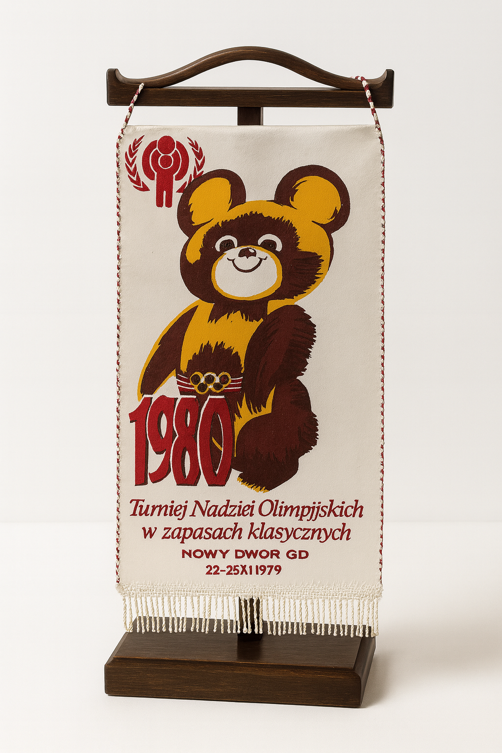Proporczyk z Turnieju Nadziei Olimpijskich w 1980 roku, przedstawiający uśmiechniętego niedźwiadka.